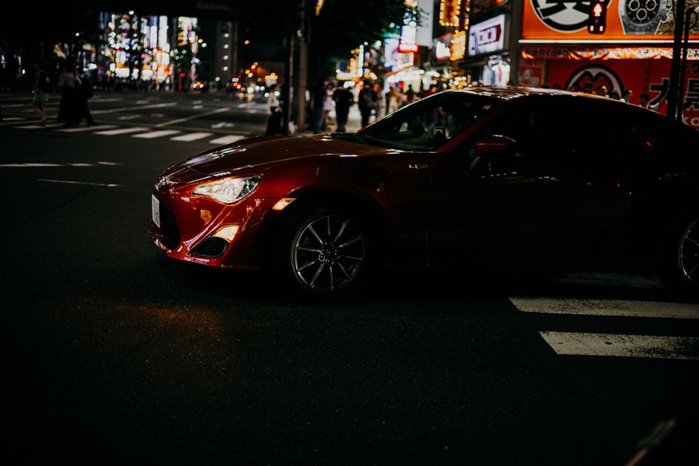 photo of a red tuning car on a street at night