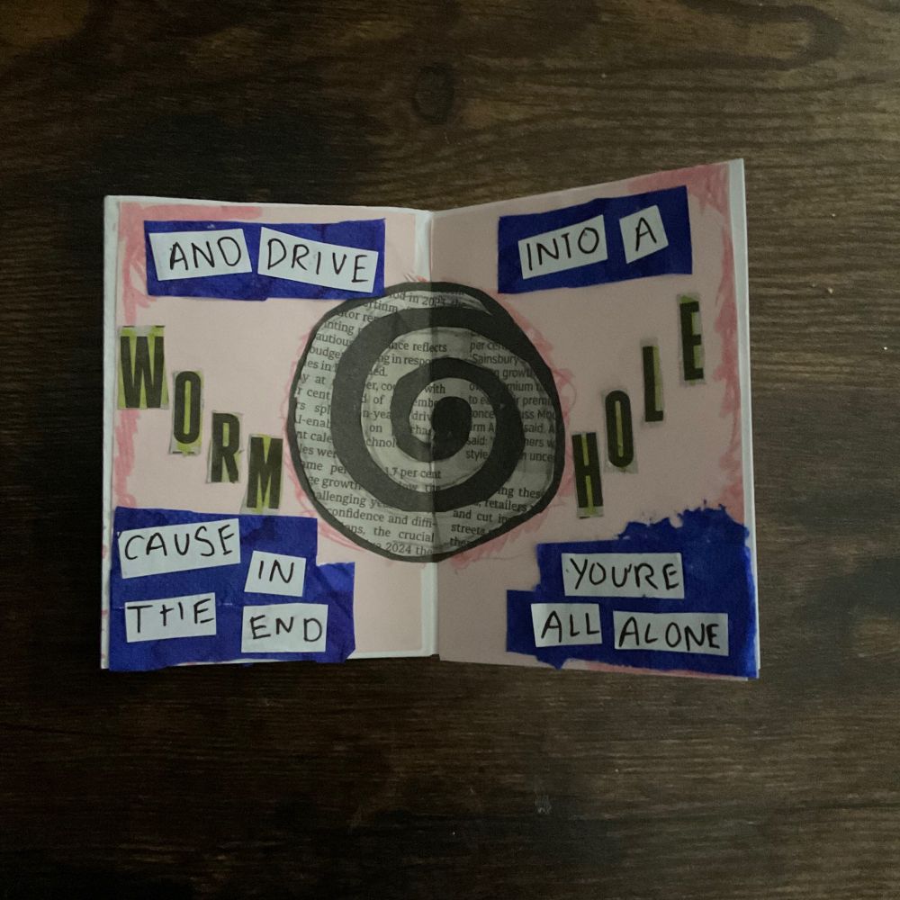 these 2 pages have a light pink background, and the text “And drive into a” is written over blue textured rectangles. a large, collaged, black and white (the white is actually newspaper clipping) swirl takes up most of the middle of the page, and the text “wormhole” is on either side of the swirl. below the swirl, on the same blue rectangles, it says : “cause in the end you’re all alone”