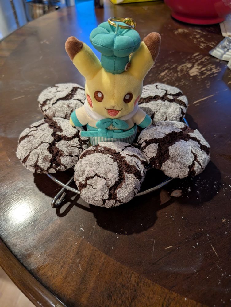 Chocolate crinkle cookies on a wire rack with a cafe Pikachu in the middle