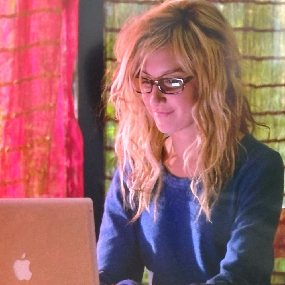 Ashley Tisdale no filme Picture This procurando no seu notebook por um videophone. A atriz usa um óculos, que é o símbolo de sua impopularidade.