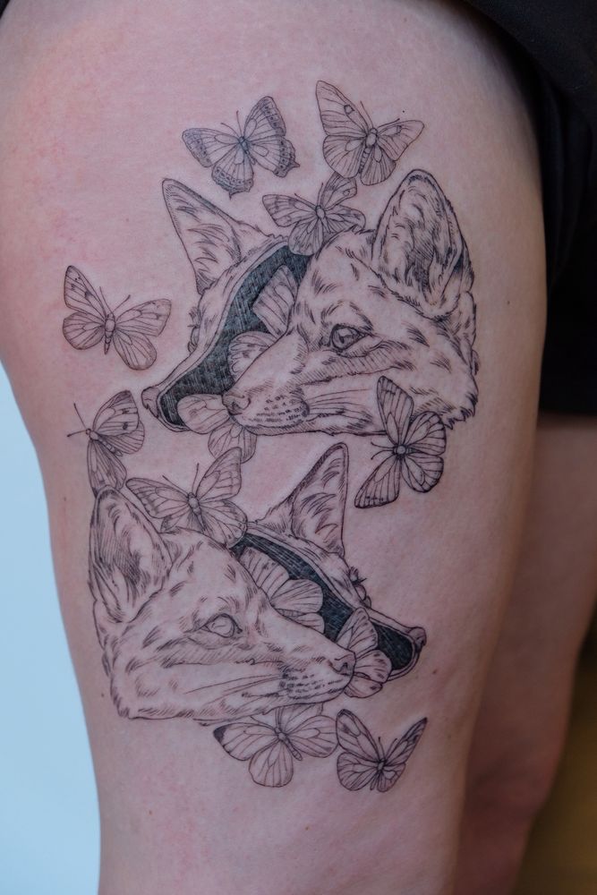 Tattoo of two fox heads split open, with butterflies flying throughout. Not gory 