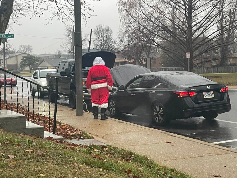 Santa getting a jump on the side of the road 