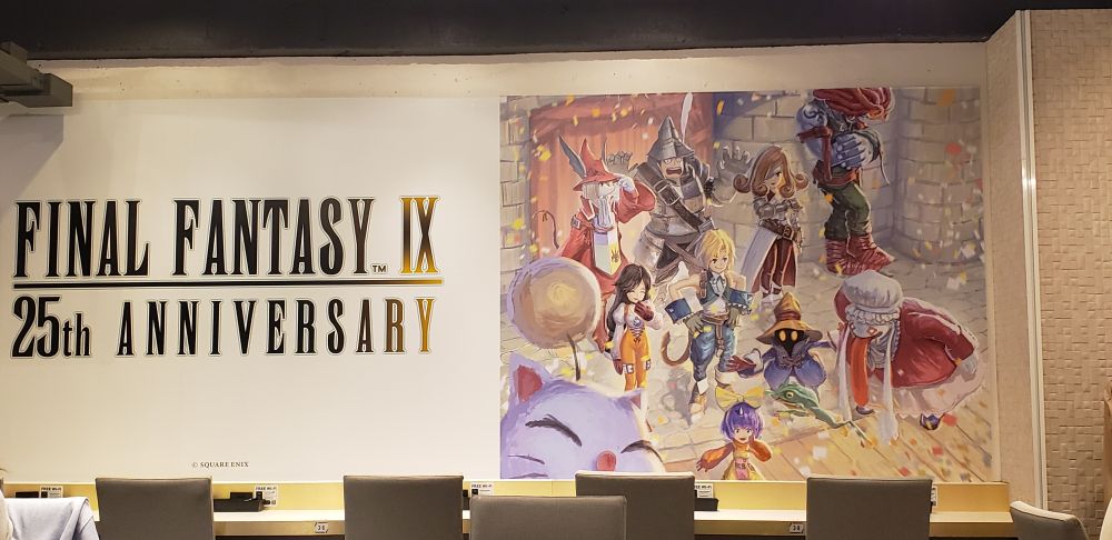 Mural in the Cafe set up for Final Fantasy IX's 25th anniversary. The image on the wall depicts the entire playable cast, including Beatrix, having a relaxing day together.