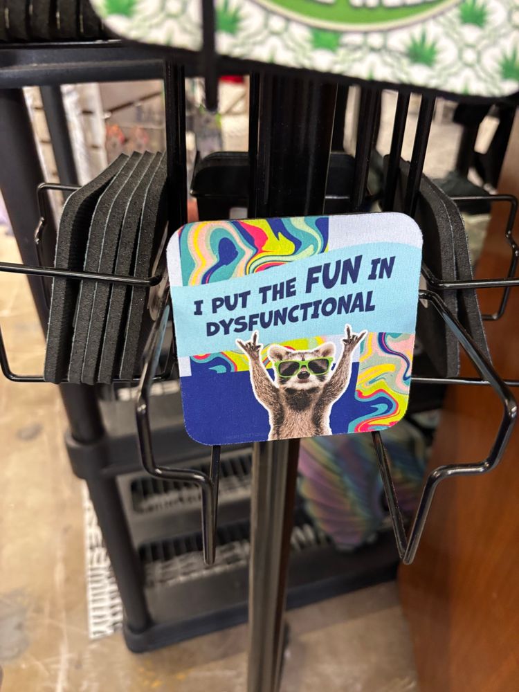 “I put the fun in dysfunctional” coaster with a raccoon throwing the rock n roll horns 