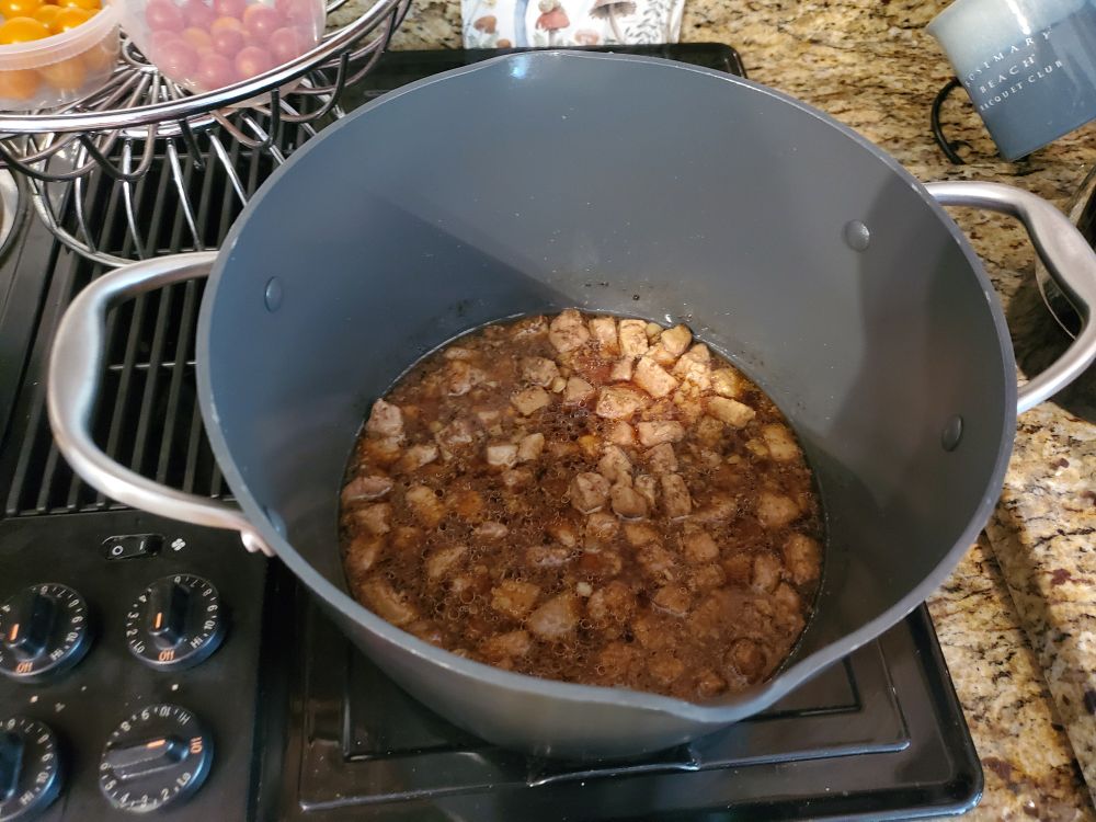 A pot of simmering pork cubes.