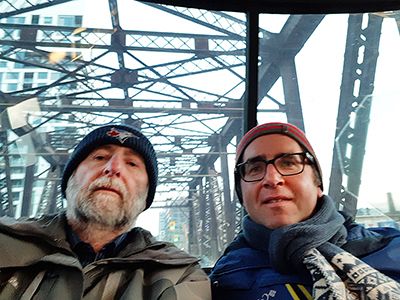 Toronto History Lecturers on the Bathurst streetcar with the metal superstructure of a bridge in the background