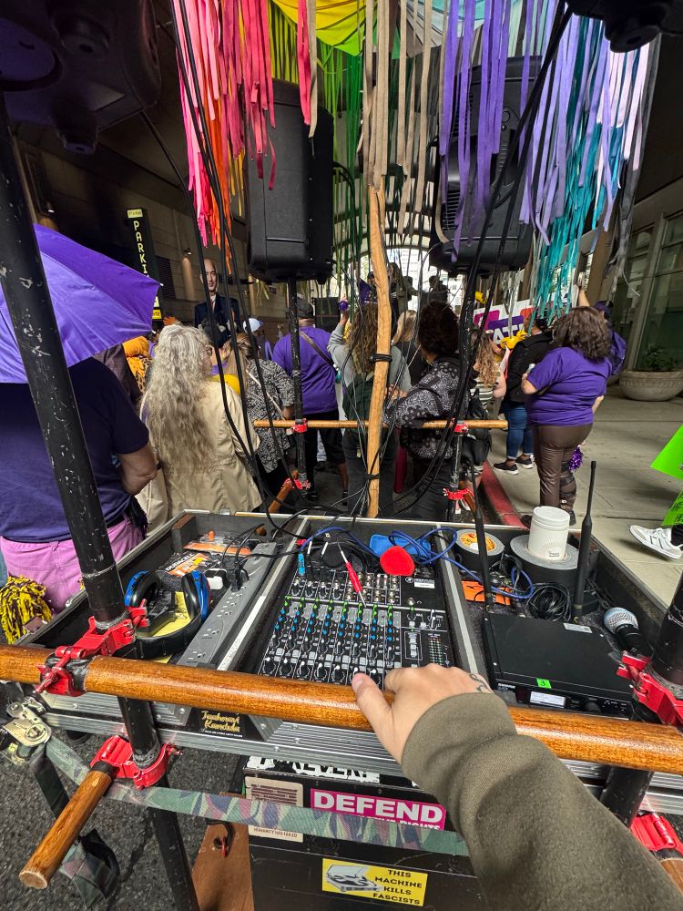 a photo of me, behind a sound board that's on a mobile cart, getting ready for a protest.