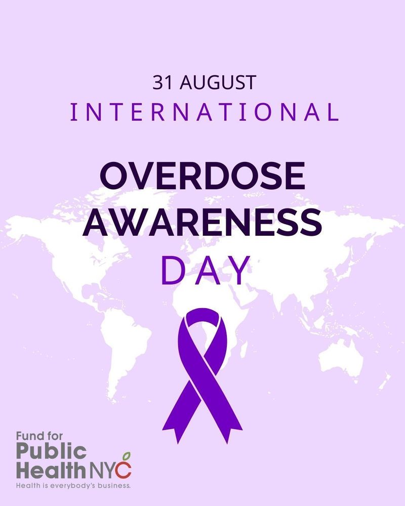 
An image for International Overdose Awareness Day on August 31st. The background is a soft, light purple with a faint, white-on-white map of the world. Centered on the image are the words "OVERDOSE AWARENESS DAY" in dark purple. Below the text is a large, stylized dark purple ribbon, which is a symbol for this day. In the upper part of the image, it says "31 AUGUST" and "INTERNATIONAL" in a lighter purple font. In the bottom left corner is the logo for Fund for Public Health NYC, with the slogan "Health is everybody's business."