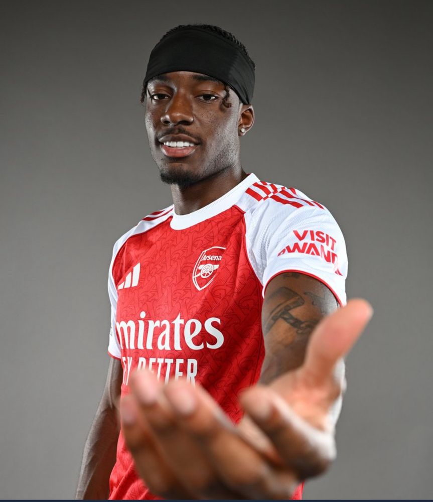 Noni Madueke wearing the arsenal home kit and holding out his hand