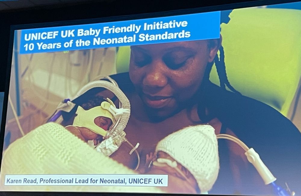 The title slide of Karen Read's presentation on 10 Years of BFI Neonatal Standards showing a mother holding premature twins skin to skin in a neonatal unit