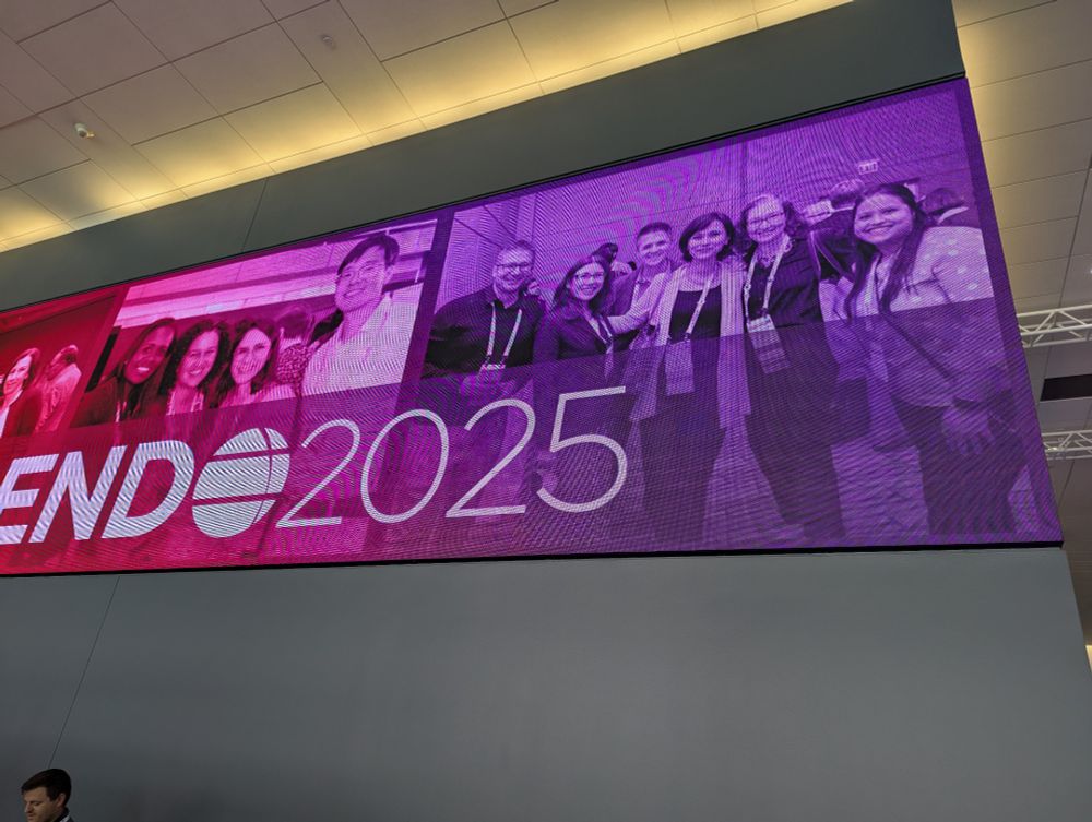 Photo of the video banner over the registration booths, includes a photo from ENDO2024 of a group of faculty from the NR IMPACT group