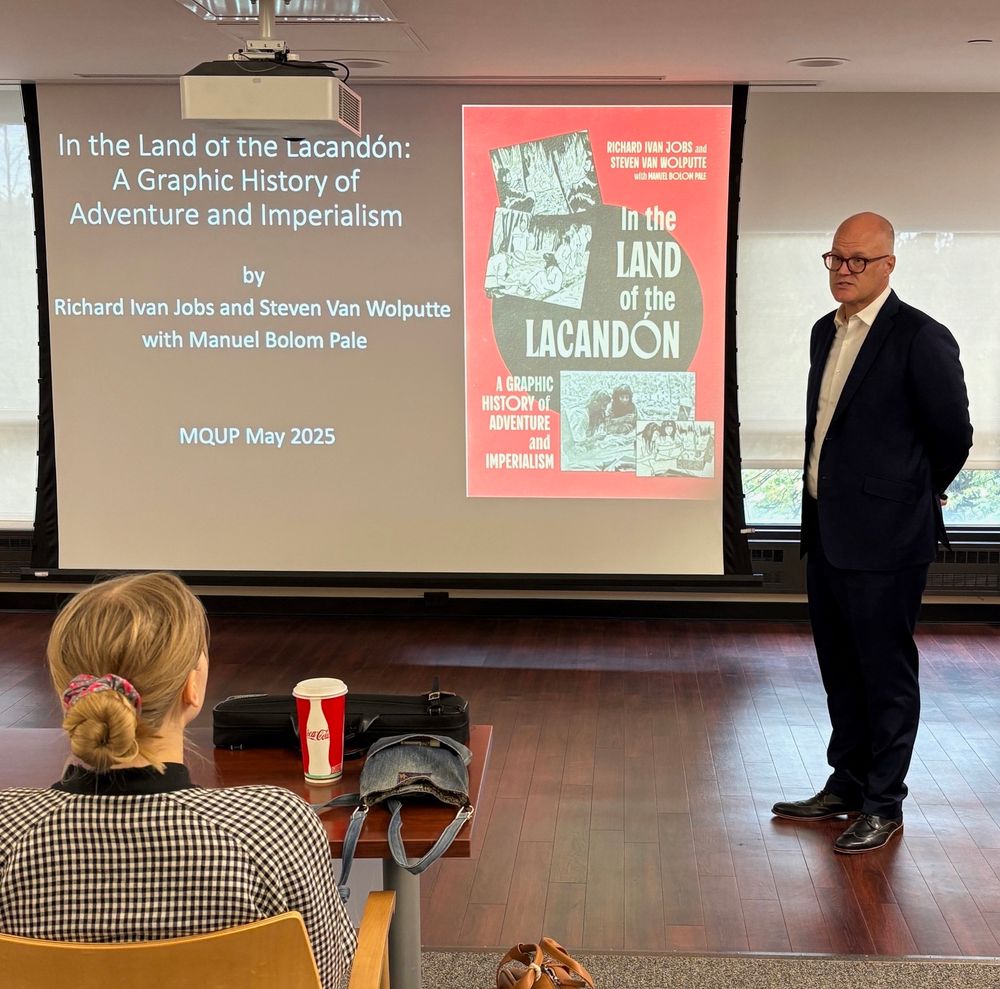 Man in suit giving book talk.