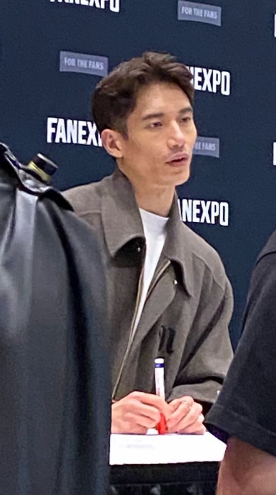Manny Jacinto looking all serious as he talks to a fan