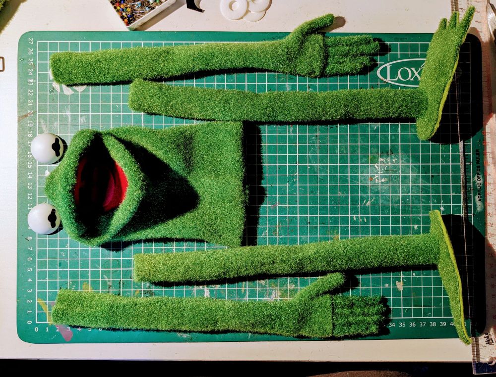Assorted, disembodied Kermit parts laid out on my desk. 