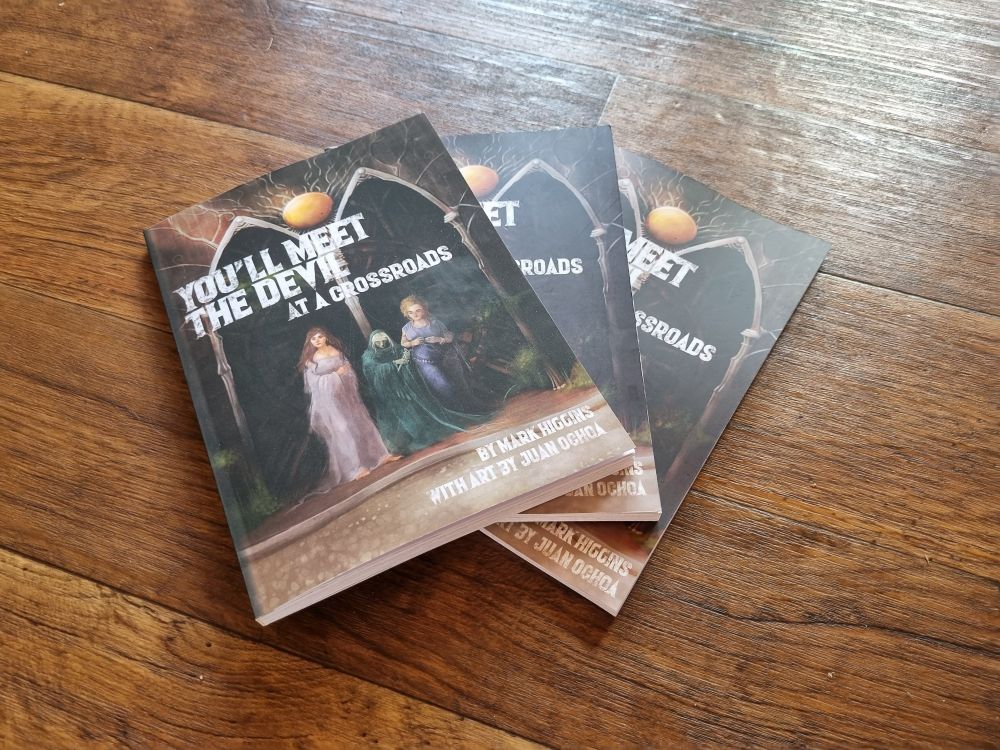 3 copies of my TTRPG book "You'll Meet the Devil at a Crossroads" on a wooden floor.  

These are 3 print samples from 3 different printers here in Australia. 
