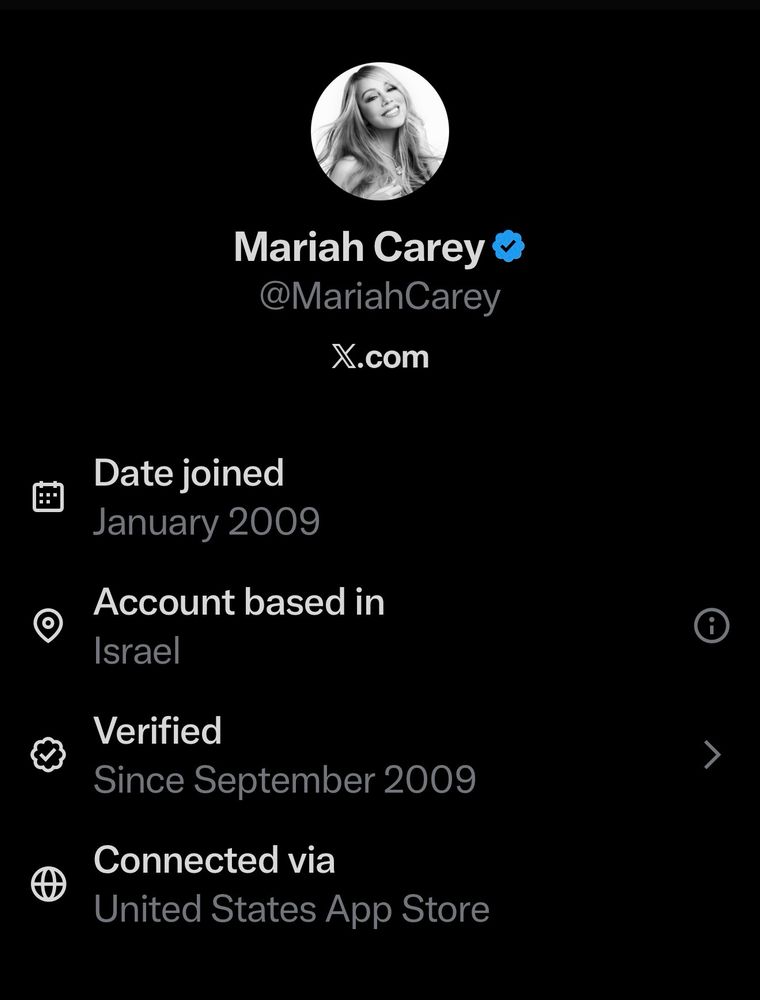 A screenshot of a social media profile on X (formerly Twitter) in dark mode with a black background. At the top is a circular profile picture of singer Mariah Carey, a woman with long wavy hair, smiling directly at the camera. Below it, the name "Mariah Carey" in white text with a blue verification checkmark, followed by the handle "@MariahCarey" in gray and the domain "x.com" in white. The profile details are listed in white text with gray icons: "Date joined: January 2009" with a calendar icon; "Account based in: Israel" with a location pin icon; "Verified: Since September 2009" with a checkmark icon; and "Connected via: United States App Store" with a globe icon.