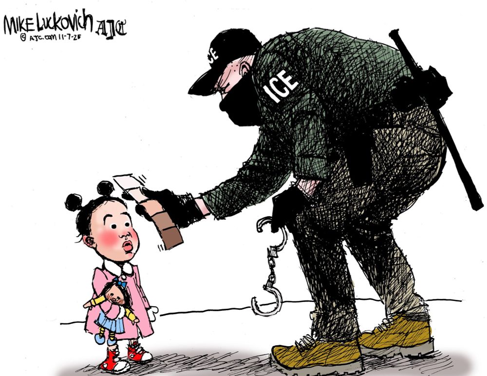 A black-and-white editorial cartoon by Mike Luckovich depicts a tall, imposing ICE (Immigration and Customs Enforcement) agent in a dark green uniform, black cap, black mask, and yellow boots, standing over a small Asian girl with pigtails, rosy cheeks, and a pink dress holding a doll. The agent, gloved and holding handcuffs in one hand, extends a passport scanner toward the frightened child with the other. In his right hand, he clutches a small notebook fanned open to show a color swatch of various skin tones, from light to dark, satirically highlighting racial bias in immigration enforcement. The composition emphasizes the agent's dominance and the girl's vulnerability, with stark line art and minimal shading for dramatic effect.