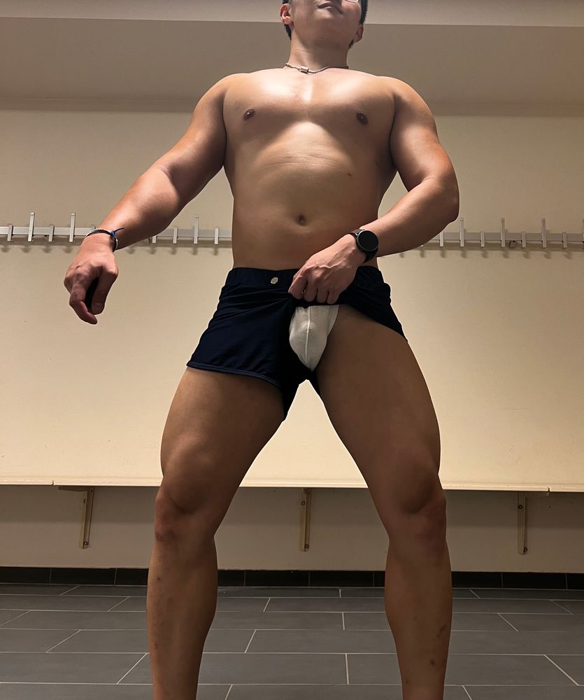 A beefy jockboy standing in the locker room all pumped after a heavy lifting session. He‘s lifting his shorts up to show off the bulge being covered by a thin jockstrap.