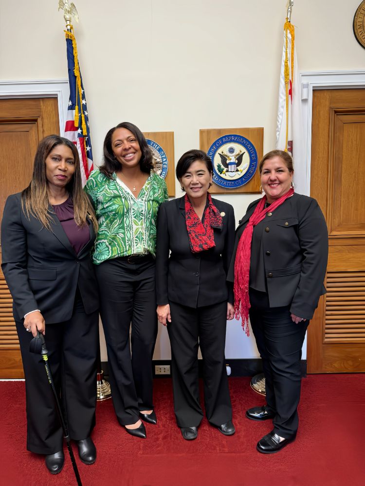 Four individuals standing together in an office with the U.S. House of Representatives seal in the background.