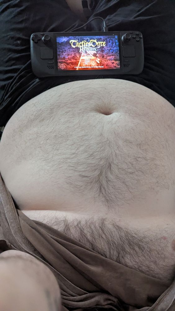 My belly and a steam deck with Tactics Ogre on