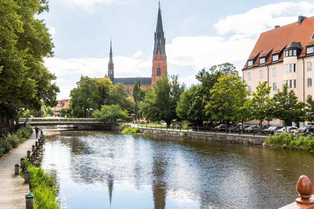 A photograph showing the Fyrisån river that flows through Uppsala, taken in the city centre with a view of the Cathedral in the background