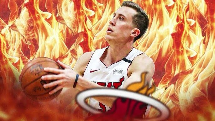 Duncan Robinson is in a basketball shooting position, Heat jersey on, surrounded by flames, Heat logo in the foreground 