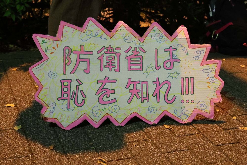 防衛省抗議・申し入れ行動の参加者が持参したプラカードの写真。
ピンク色に枠が縁取られたプラカードは地面にも置けるようになっていて、「防衛省は恥を知れ!!!」と大きく書かれている。
