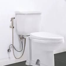 Photo of a toilet with a hose-style bidet attached.