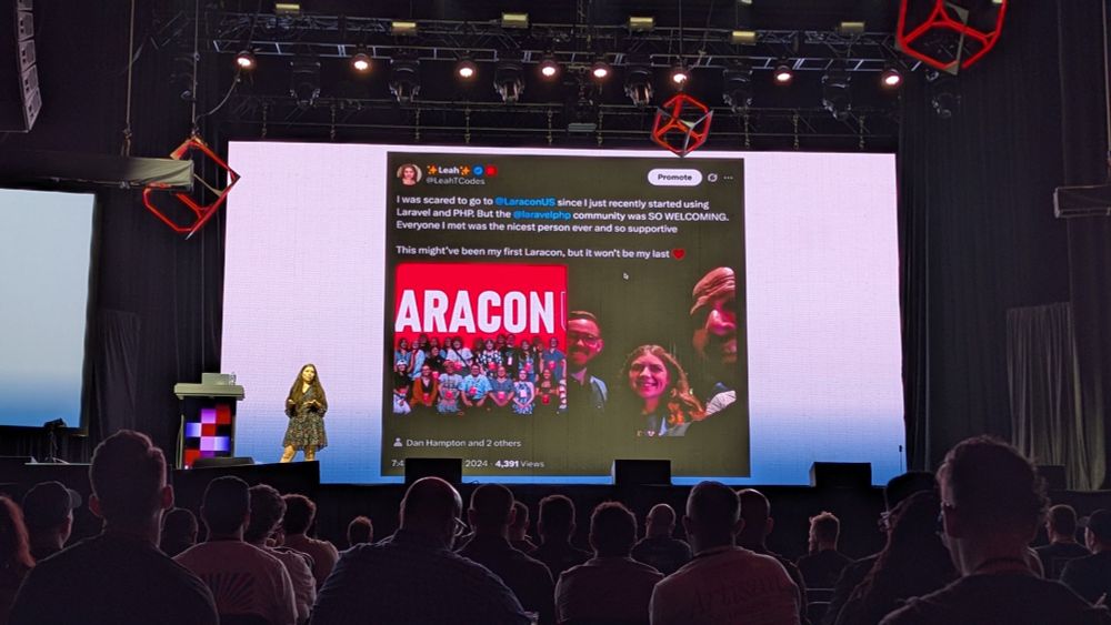 Leah Thompson, a woman with reddish brown hair and blue eyes, is standing on the stage at Laracon US 2025 giving a talk.