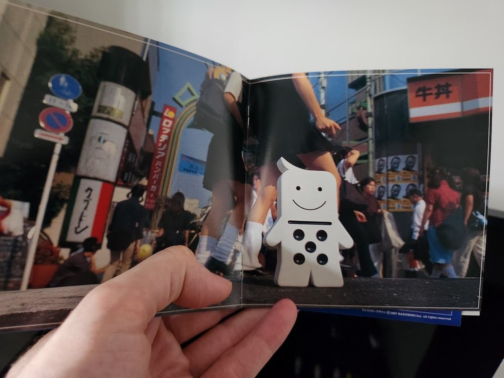 an odd photo from the Mr Domino manual which is a real life photo of a forced perspective Mr Domino in a real, busy street in Japan