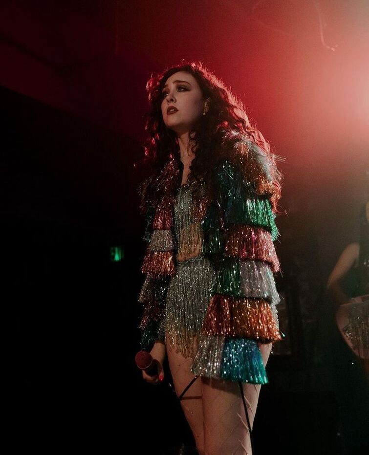 Chappell Roan performing in a spangled silver outfit with multicolored fringed sleeves. Photo DAPHNE STUBBLEFIELD.