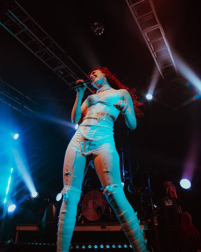 Chappell Roan performing in white lingerie and leggings adorned with bows. Photo @jadelynnphoto.