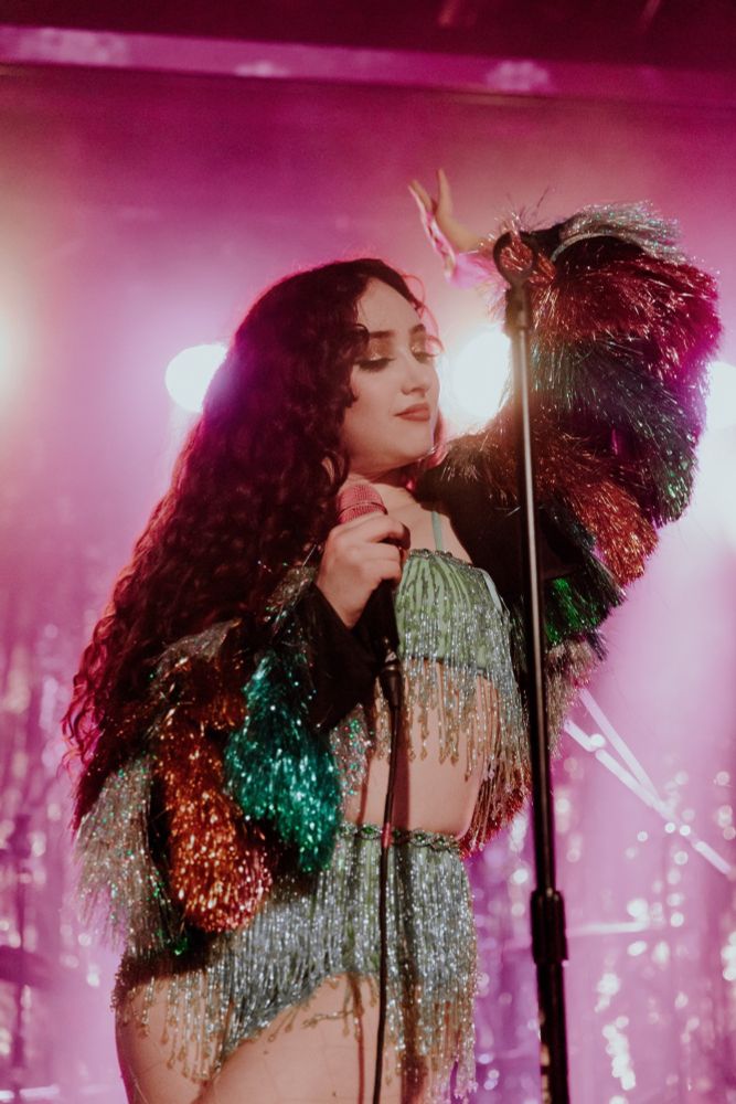 Chappell Roan performing in a spangled silver outfit with multicolored fringed sleeves. Photo DAPHNE STUBBLEFIELD.