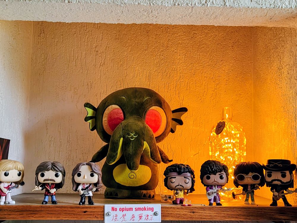 Cute stuffed cthullu standing guard over our dead and alive favourite musicians (rush, jimmy, prince, joey, lemmy)
A sign saying 'no opium smoking ' underneath 