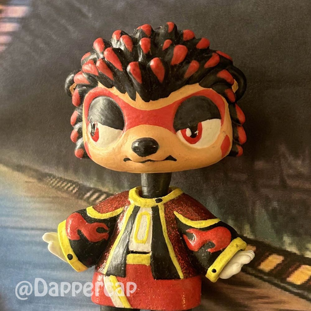 A hand-painted custom hybrid mini doll inspired by Shadow the Hedgehog, standing in one of the corridors of the ARK station.

Head came from a Littlest Pet Shop Hedgehog and the outfit/body came from a Yummiland keychain doll.