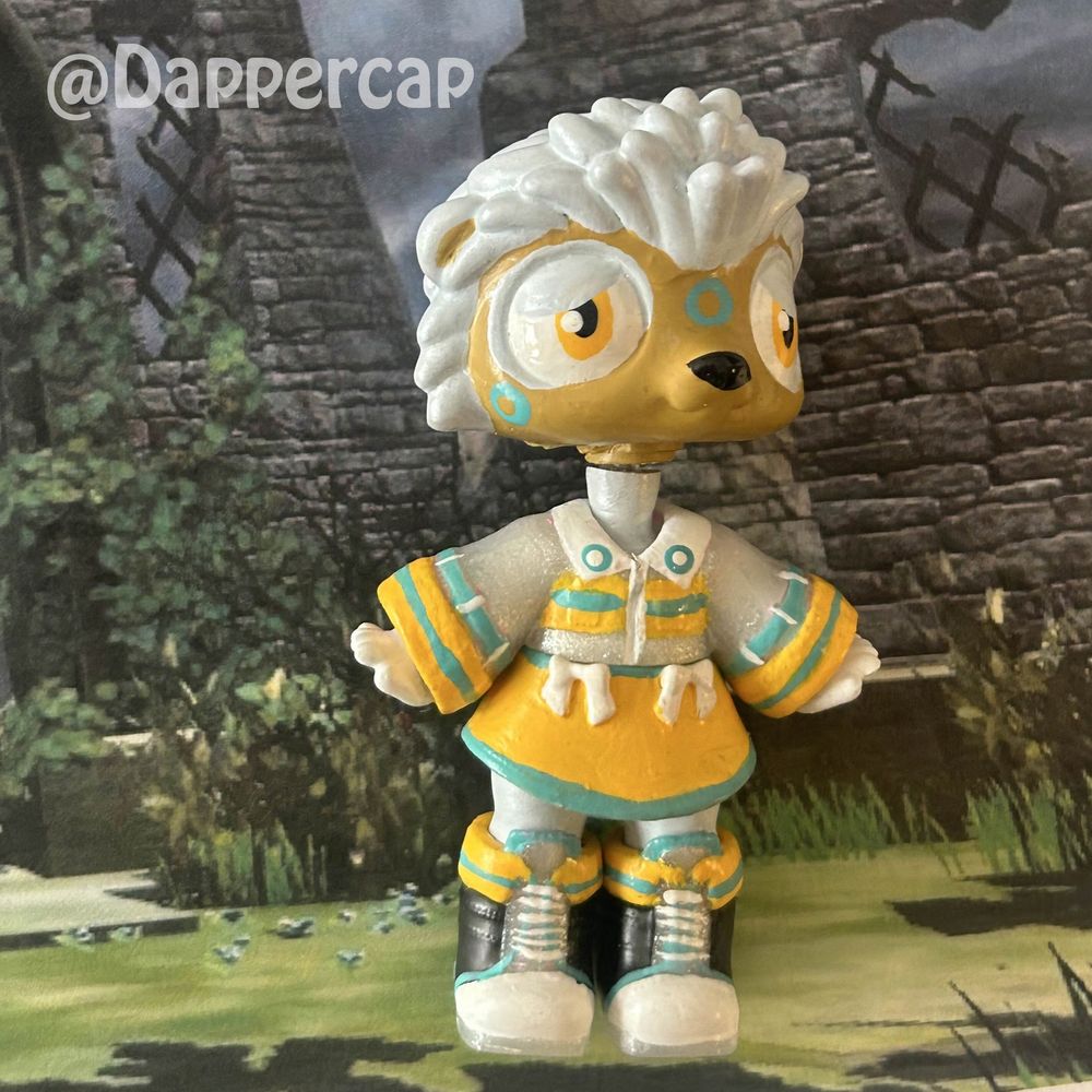 Picture of a hand-painted hybrid mini doll inspired by Silver the Hedgehog, standing in some overgrown ruins.

Head came from a Littlest Pet Shop Hedgehog and the body/outfit came from a Yummiland Doll.