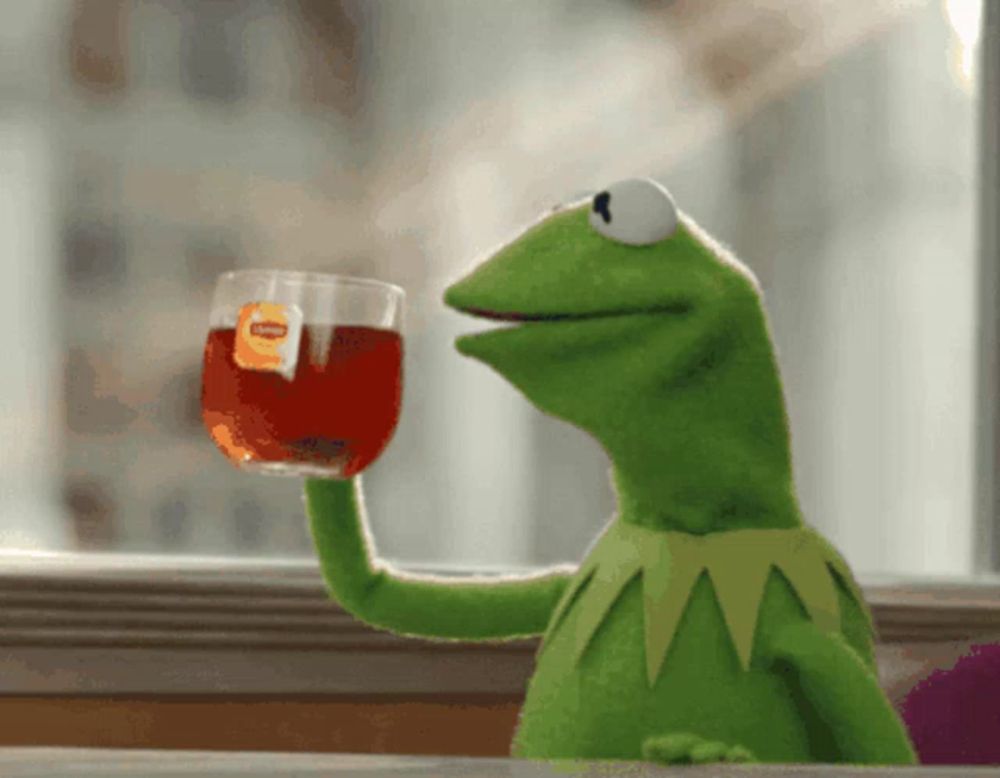 kermit the frog is holding a glass of tea