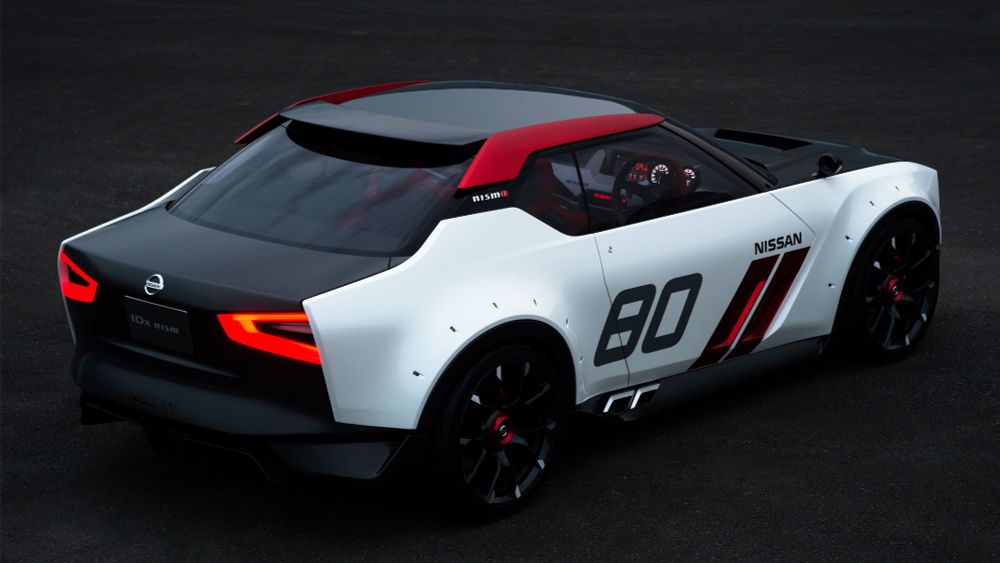Nissan IDx NISMO, a retro-styled 2-door kammback sports coupé; white sides, black top, red details; "80" is painted on the side doors, like a race number. the wheels have flared arches, with fake bolt holes to imitate an aftermarket modification. rear 3/4 view, presumably outdoors