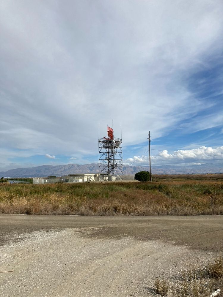 A RADAR station across the marshland, with Mission Peak and clouds across the SF Bay