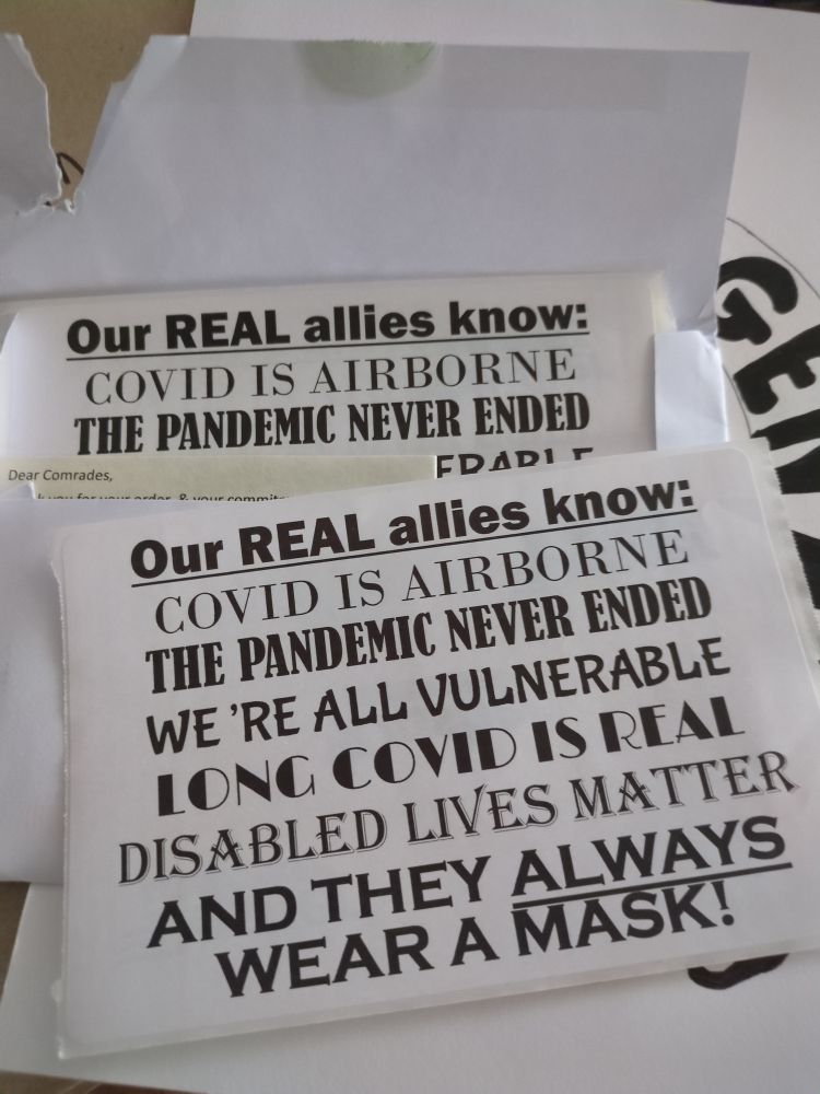 Stack of stickers. They say
es,

Our REAL allies knoW:
COVID IS AIRBORNE
THE PANDEMIC NEVER ENDED
WE 'RE ALL VULNERABLE
IONG COVID IS REAL
DISABLED LIVES MATTER
AND THEY ALWAYS
WEAR A MASK!