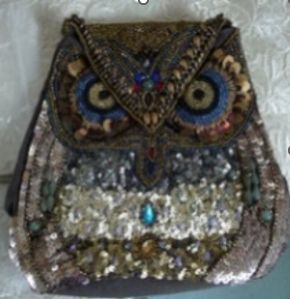 Blurry photo of a heavily beaded bag in the shape of an owl.