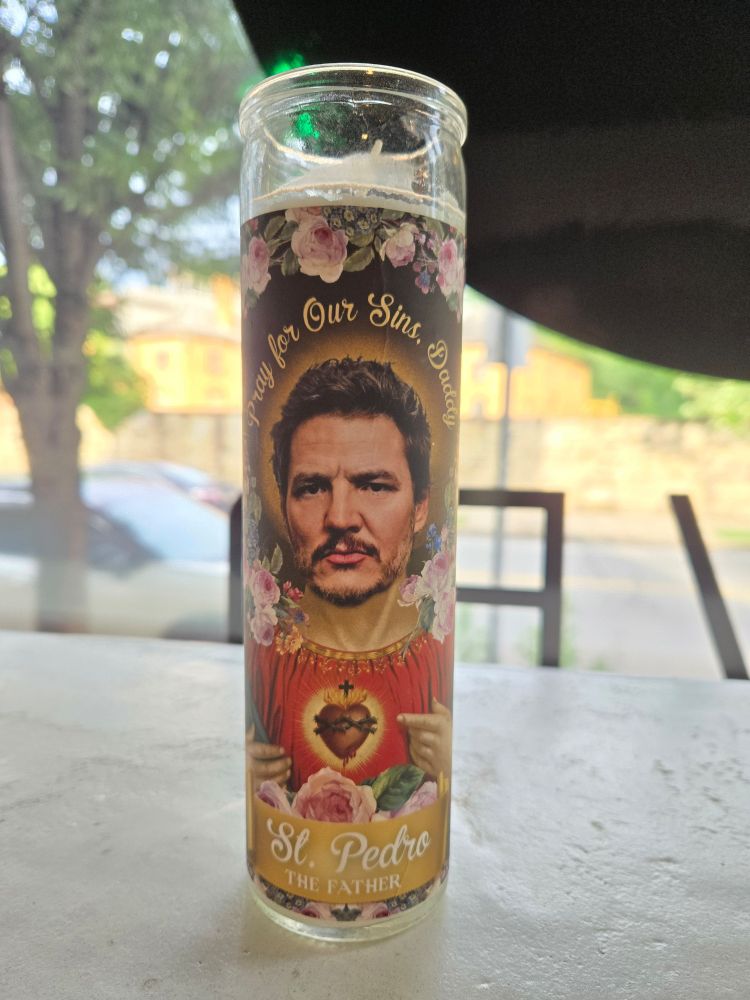 Prayer candle with Pedro Pascal's face on it. It says pray for our sins, Daddy. And Saint Pedro, the father.