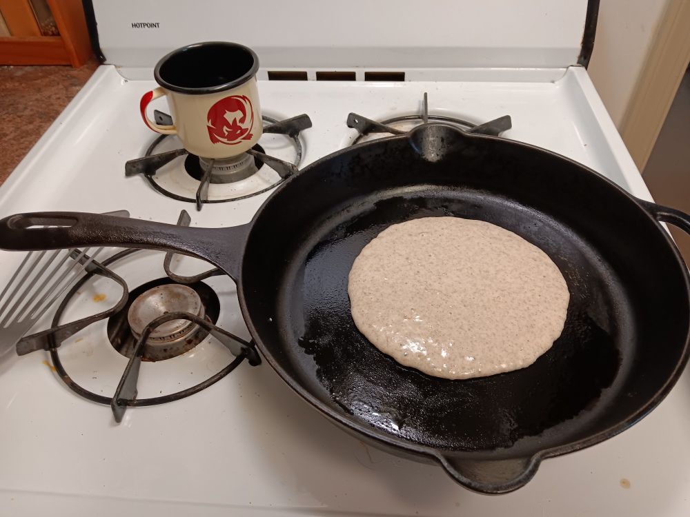 Freshly poured Pancake batter in a cast iron skillet