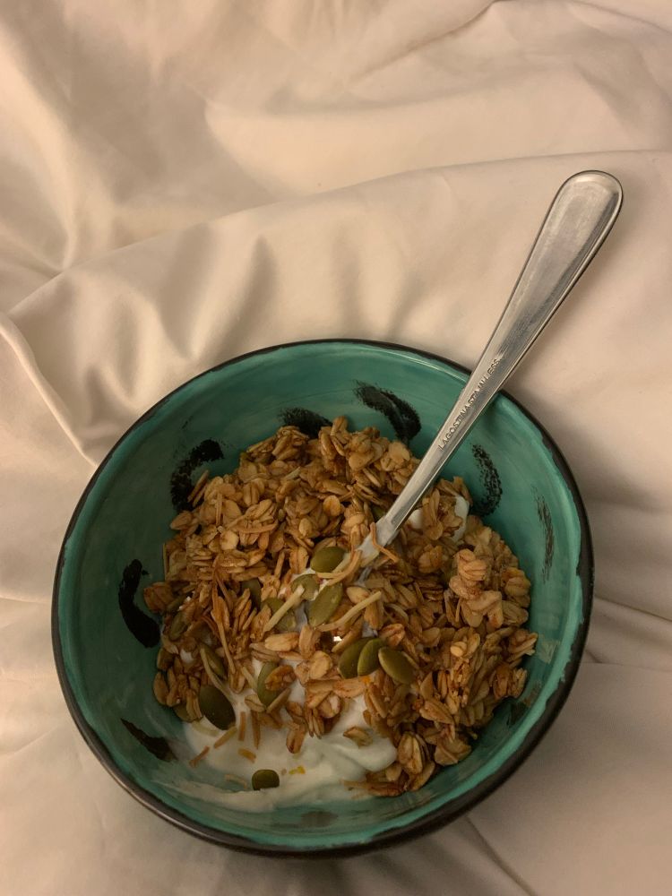 Turquoise with black swishes in it, containing Greek yogurt and homemade granola. I added orange zest to the granola. It’s now my favourite ❣️