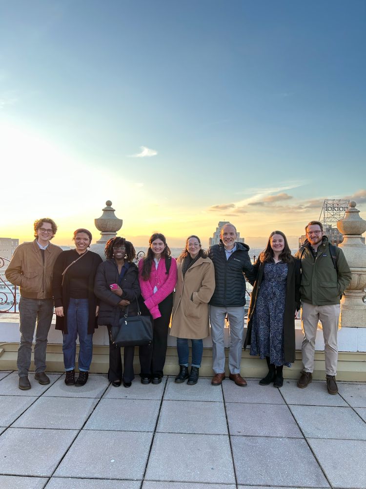Group of people standing on hotel roof at sunset 