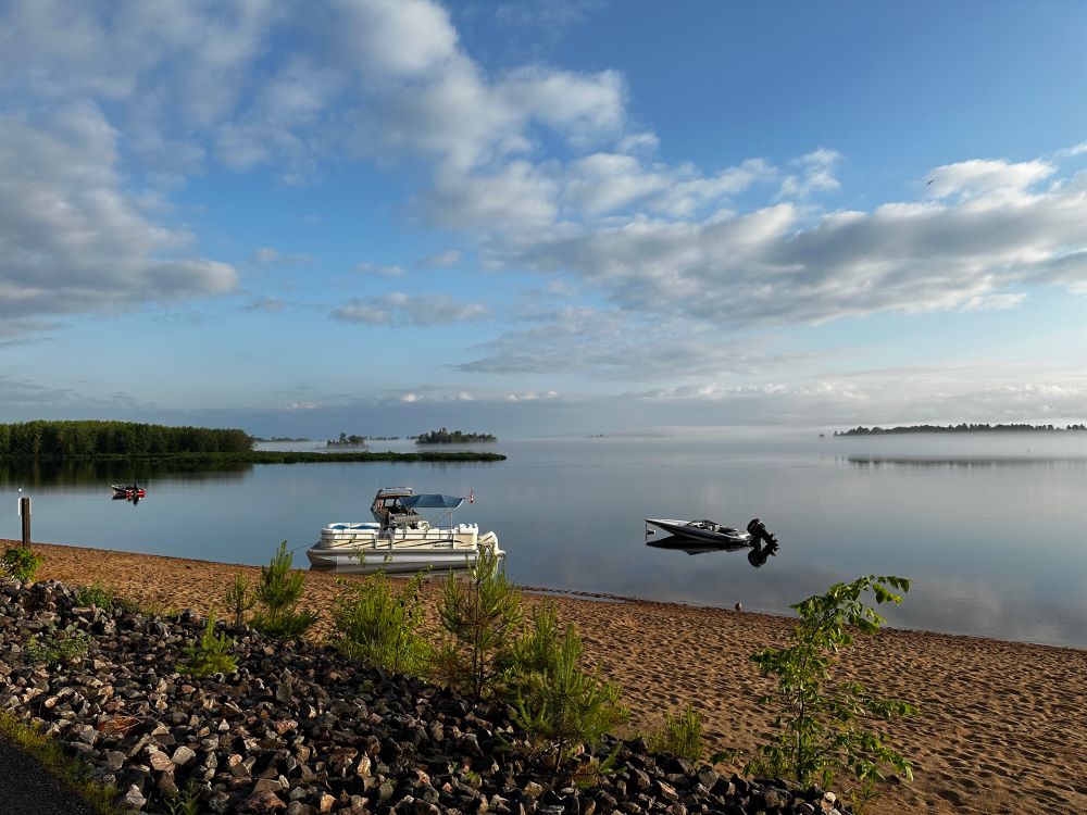 Ottawa River with sparse clouds and boats in the foreground.