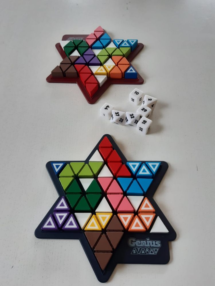 Zwei mit bunten Klötzen belegte sternförmige Spielfelder des Spiels GeniusStar