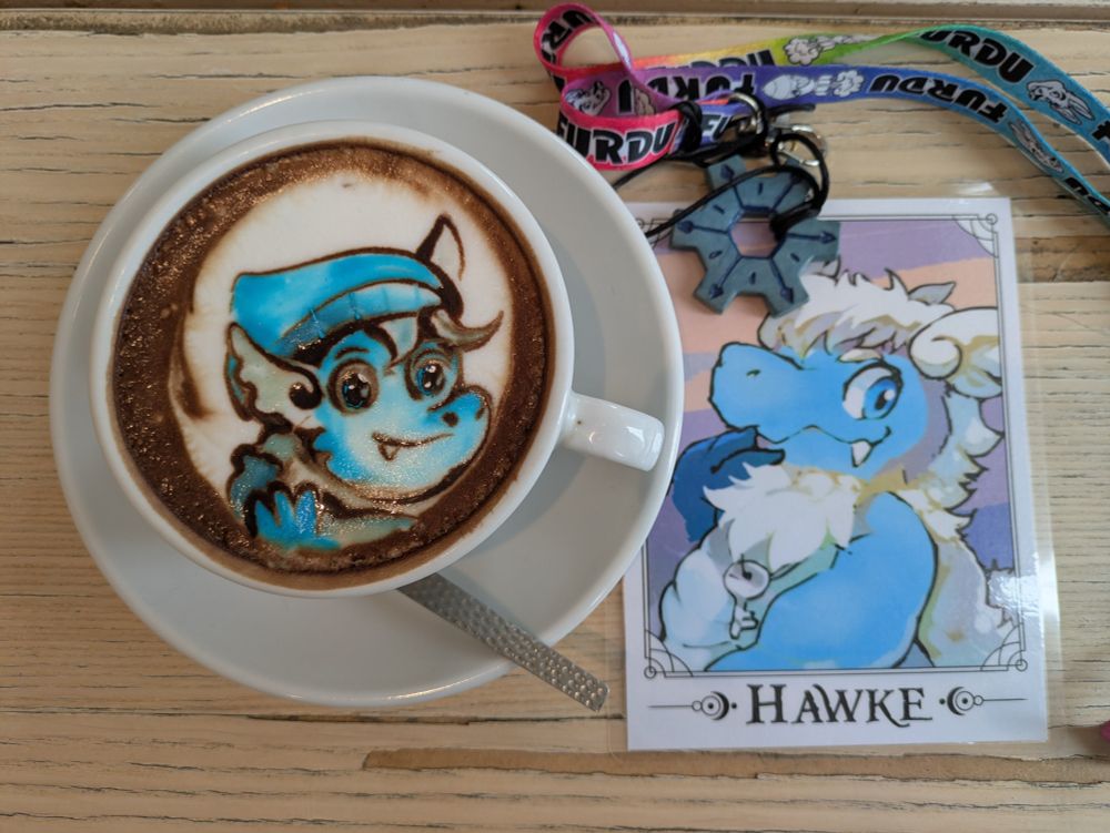 photo of latte art depicting hawke with a hawke badge next to it