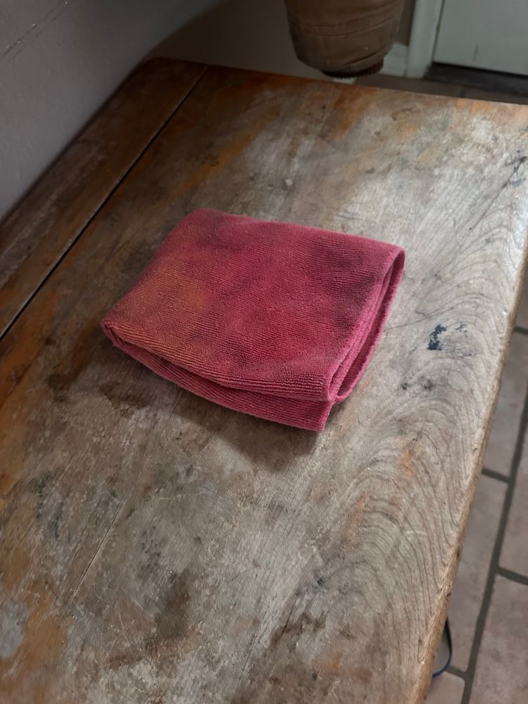 Microfiber cloth folded into a square on a repurposed school desk