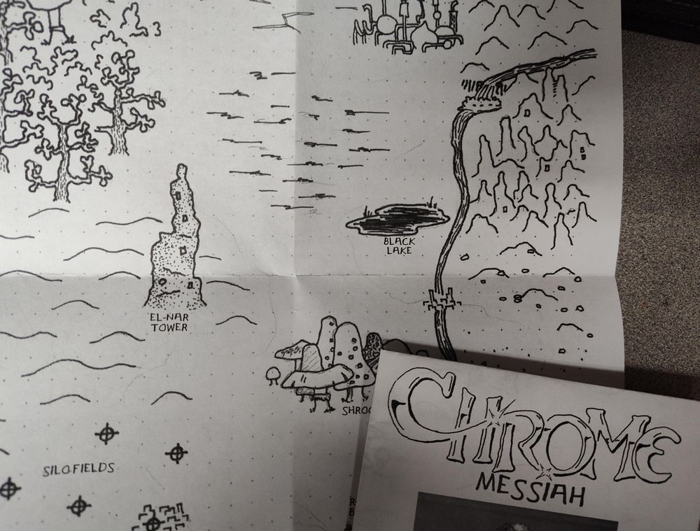 Photo of printed draft dummies of part of map (black and white pen and ink drawing) and cover for "The Chrome Messiah" 